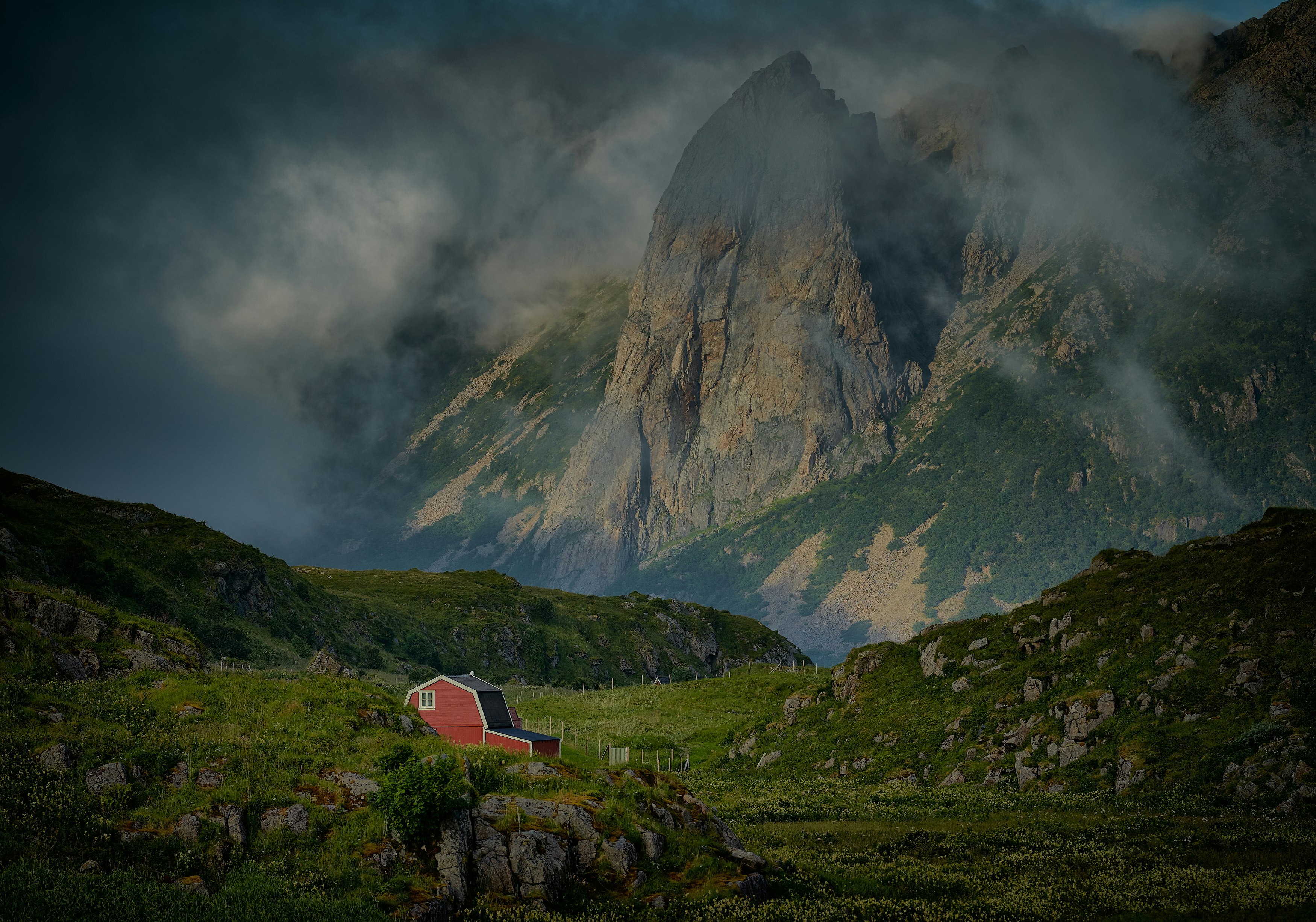 white and red house on green grass field near mountain